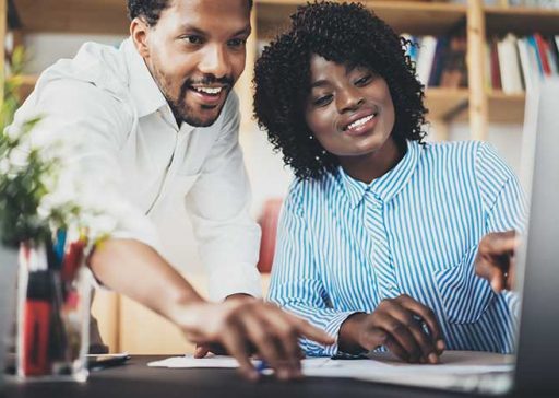 Two young coworkers working together in a modern office.Black business partners discussing new startup project.Horizontal,blurred. Two young coworkers working together in a modern office.Black business partners discussing new startup project.Horizontal,blurred