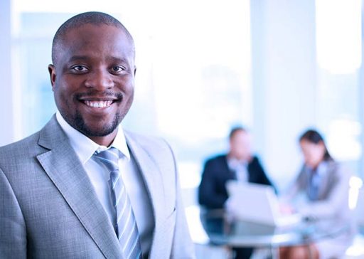 Image of African-American business leader looking at camera in working environment